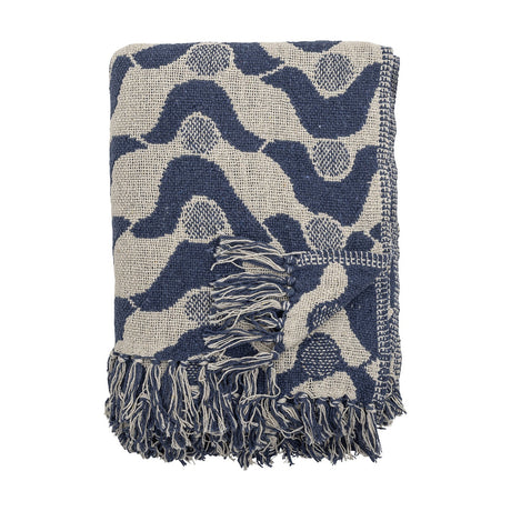 Santena Wavy Cotton Throw in blue, folded, showing a textured woven wave pattern with dotted circles and fringed edges, against a plain white background.