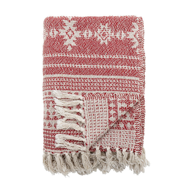 Folded Oia Snowflake Cotton Christmas Throw in red, woven with snowflake motifs and fine stripes, finished with knotted cream tassel fringe, shown on a white background.