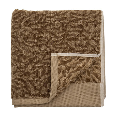 Kaysa Cotton Towel 100x50cm in brown, folded to show a coral-like woven pattern in light and dark brown tones with a plain woven border, on a white background.