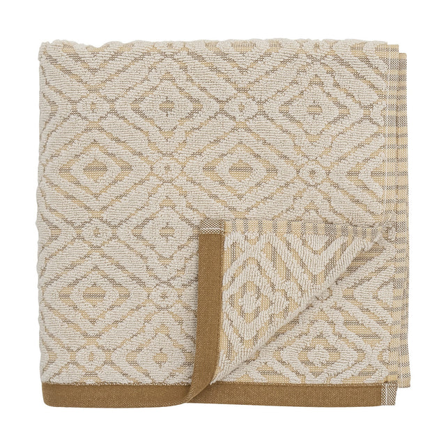 Malou Cotton Towel in Natural, folded hand towel with a woven geometric diamond pattern in cream and mustard, finished with a mustard-brown edge trim, on a white background.