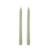 Pair of Ponza LED taper candles in green paraffin wax with a spiral-twist body, fluted base, and flame-shaped tip, shown on a plain white background.