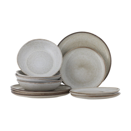 Sandrine Speckled Stoneware Dinner Set of 12 in beige, with dinner plates, side plates and deep bowls stacked on a plain white background.