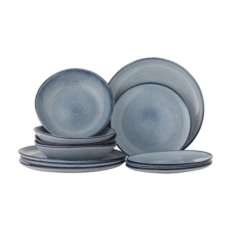 Sandrine Stoneware Dinner Set of 12 in blue, with stacked dinner plates, smaller plates, and deep bowls in a reactive glaze finish, shown on a plain white background.
