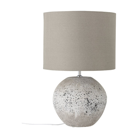 Isedora Stoneware Table Lamp with grey linen drum shade and a rounded, speckled stoneware base, shown on a plain white background.