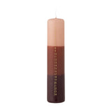 Tall slim pillar candle dip-dyed in pink, terracotta, and dark brown bands, featuring a gold 1–24 advent countdown printed down one side, shown on a white background.