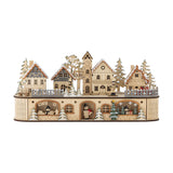 Norwich Wooden Christmas Decoration with Light in beige, a lit wooden village scene with gabled houses, a clock tower, fir trees, a street lamp and figures on an arched-window base.