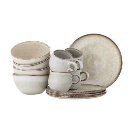 Sandrine Stoneware Breakfast Set of 12 in beige, with four stacked bowls, four handled cups and four plates, all in a speckled reactive glaze with darker rims, shown on a plain white background.