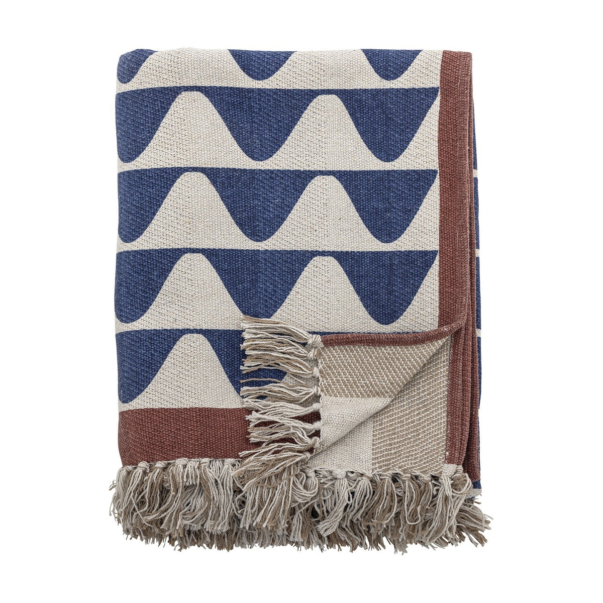 Rimme Cotton Throw in multi, folded to show a bold navy wave pattern on cream with a rust border, fringed edge, and a woven stripe reverse, against a plain white background.
