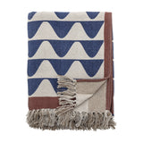 Rimme Cotton Throw in multi, folded to show a bold navy wave pattern on cream with a rust border, fringed edge, and a woven stripe reverse, against a plain white background.