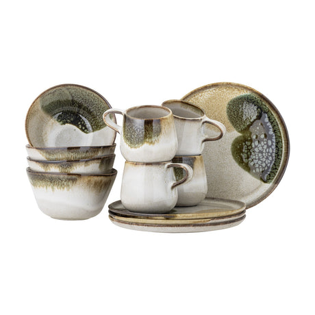 Jules Stoneware Breakfast Set of 12 in cream, with four mugs, four bowls and four plates in reactive glaze with green-brown streaks, shown on a white background.