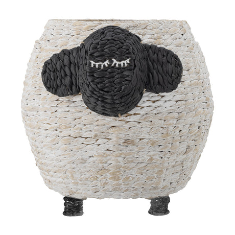 Dolly Sheep Water Hyacinth Basket in white, a round woven storage basket with a black sheep face, stitched sleepy eyes, two ears, and short raised legs, on a plain white background.