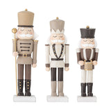 Darryl Resin Christmas Decorations Set of 3 in brown, three nutcracker-style figures with tall hats, moustaches and buttoned jackets, one holding a staff, one a drum, on a plain white background.