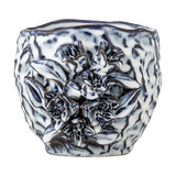 Malina Floral Stoneware Plant Pot in blue with a rippled, crinkled texture and a raised floral and leaf cluster in relief on one side, shown on a plain white background.