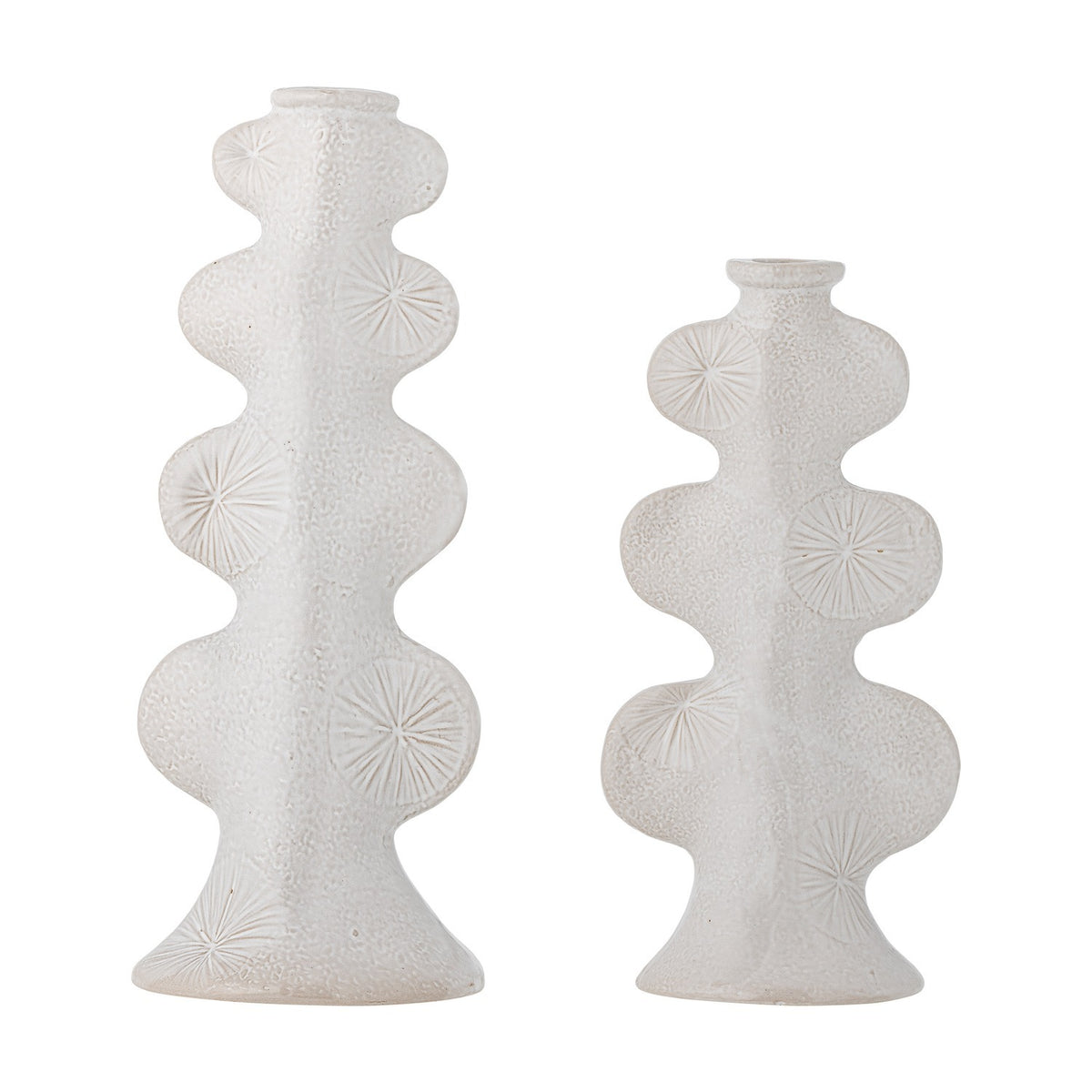 Cason stoneware candle holders in white, set of two different heights with rounded lobed columns, flared feet, narrow collars, and sunburst motifs on a textured glaze, shown on a plain background.