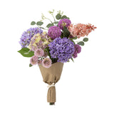 Edge Artificial Bouquet in Purple, a faux floral arrangement with hydrangea clusters, pompom heads and seed sprigs, wrapped in kraft paper, on a plain white background.