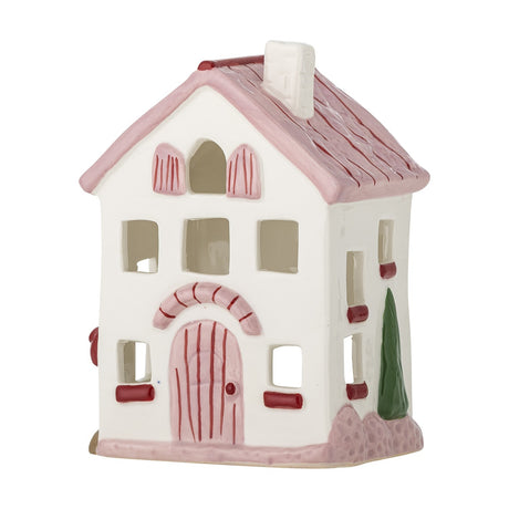 Shirly House stoneware tealight holder shaped like a two-storey home, with white walls, a pink pitched roof and chimney, cut-out windows, and a pink arched door, shown on a plain white background.