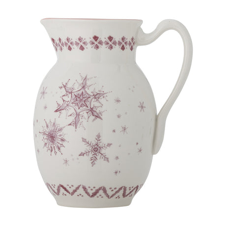 White stoneware Christmas jug with curved handle and pouring lip, featuring pink snowflake motifs and a patterned border, set against a plain white background.