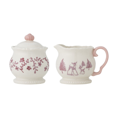 Cream stoneware Wonderland Christmas milk jug and lidded sugar bowl, jug with deer and fir trees, bowl with floral branches, pink handle and knob, beaded feet.