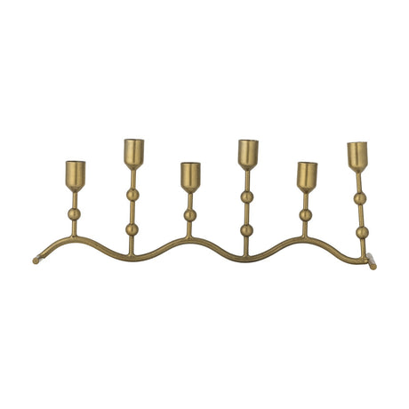Kiri Wavy Iron Candle Holder in brass, a wave-shaped metal base with six taper candle cups at alternating heights joined by ball details, shown on a plain white background.