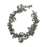 Artificial cedar Christmas garland coiled into a wreath-like loop, with frosted green needle clusters along a flexible branch, shown on a plain white background.