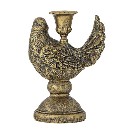 Fosna bird-shaped resin candle holder in distressed brass finish with carved wing feathers, fanned tail, and taper candle cup on its back, set on a stepped round pedestal.