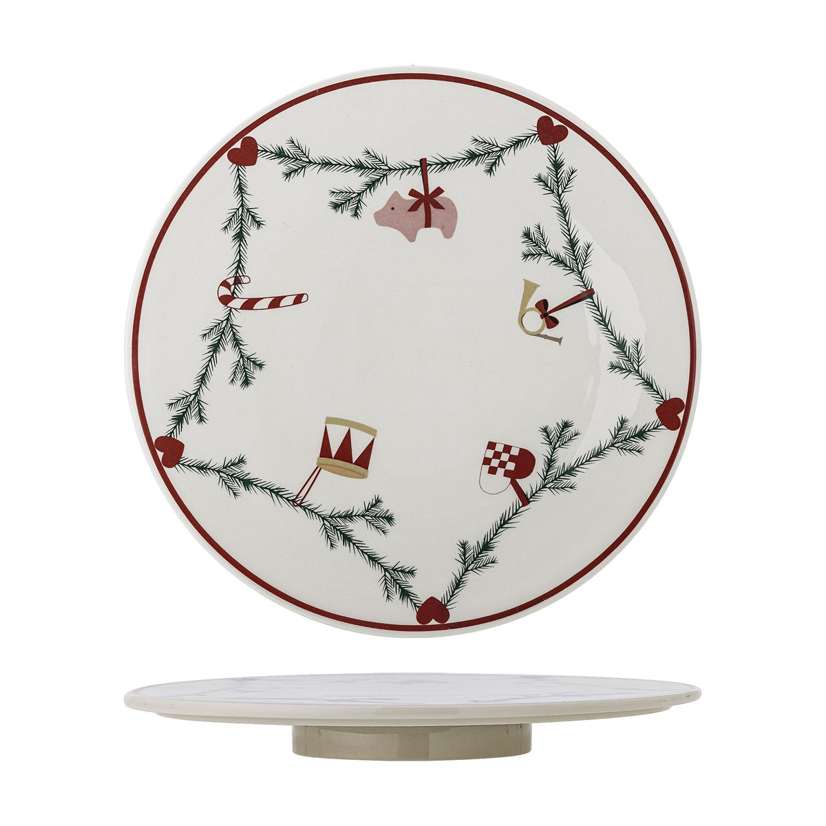 White stoneware lazy Susan with a fir garland and heart motifs linking a pig, candy cane, drum, horn and flag, on a low round base, plain white background.