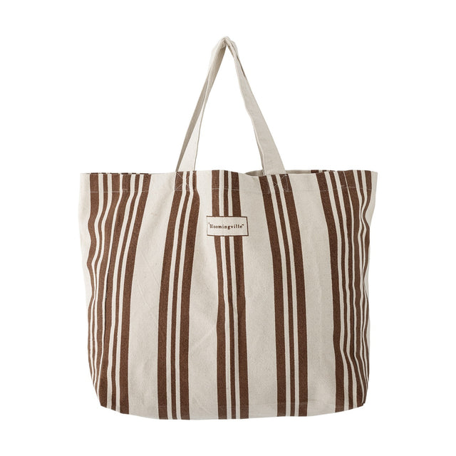 Trina Striped Cotton Shopping Bag in brown and natural vertical stripes, with twin fabric handles and a woven label, shown on a plain white background.