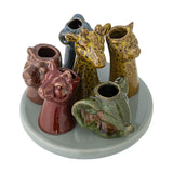 Piero Stoneware Vase 10.5cm in Multi, six animal head vessels including giraffes, a ram, and an elephant rising from a round ceramic base, set on a plain white background.