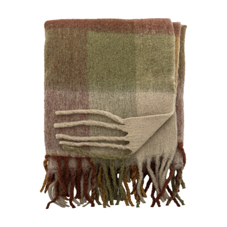 Hamisha Throw in Multi, a folded woven blanket with a muted green, terracotta and beige check pattern and chunky twisted fringe, shown on a plain white background.