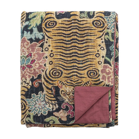 Lester Floral Cotton Throw in Multi, folded to show a floral and wavy stripe pattern in gold, black, and pink with a plain dusky pink reverse, on a white background.