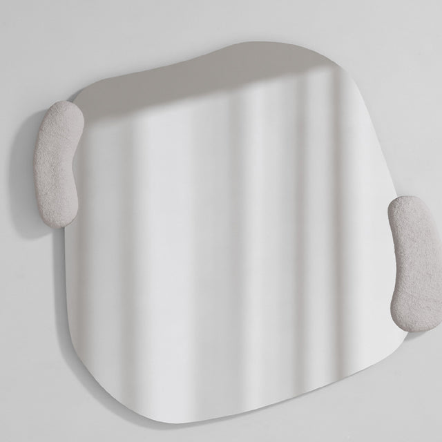 Irregular sculpted wall mirror with two moulded white forms held against its edge, the glass curving between them.