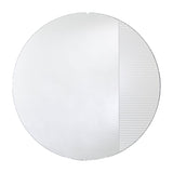 Round frameless mirror, one part plain and one part vertically fluted so the reflection breaks into bands, on a plain background.