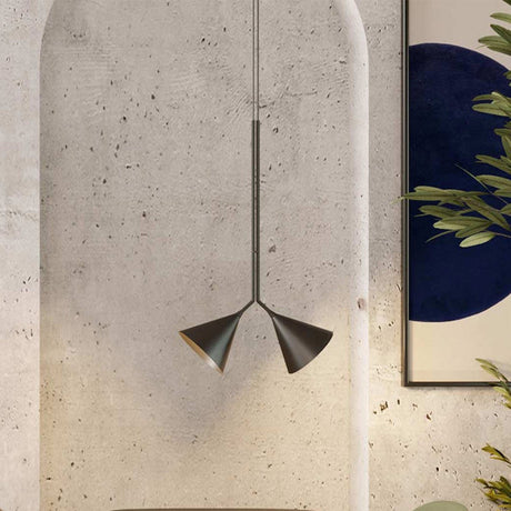 Rubi Duo Cone Pendant light with two angled cone shades in matt black with gold interior, hung from a slim rod against a textured concrete archway.