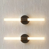 Roos LED Cylinder Disc Wall Light in matt black, two fixtures with horizontal acrylic tubes either side of round discs, mounted on a textured light grey wall.