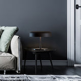 Rea 3 Light Dome Mushroom Table Lamp with matt black aluminium shade and dark marble base, shown on a side table beside a sofa in a living room setting.