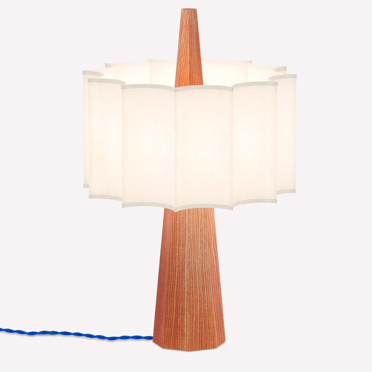 Rain Scalloped Fabric Table Lamp in chestnut, with a tapered wooden base, central wood spire, white scalloped fabric shade, and blue textile cable, shown on a plain white background.