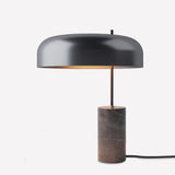Romina Dome Mushroom Table Lamp with matt black aluminium dome shade on a slim stem, set on a dark marble cylindrical base, shown on a plain white background.