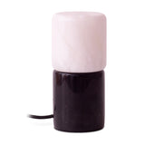 Rock Cylinder Alabaster Table Lamp with a pale alabaster cylindrical shade stacked on a glossy black marble base, fabric cord visible, set on a plain white background.