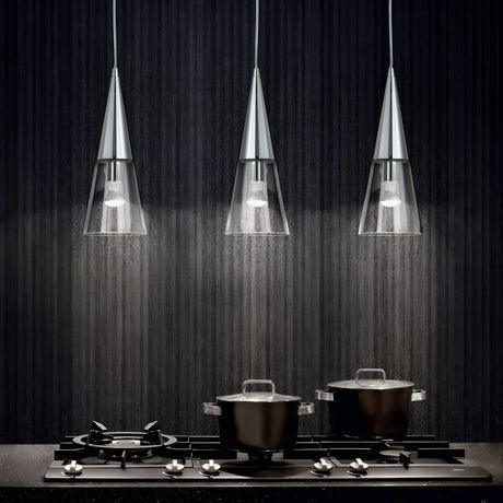 A modern kitchen scene with a black stovetop featuring three burners. Two pots with lids are on the stove. Above, three sleek Cone 1 Light Glass Pendants in silver with adjustable cable lengths illuminate the dark textured wall, creating a stylish, contemporary look.
