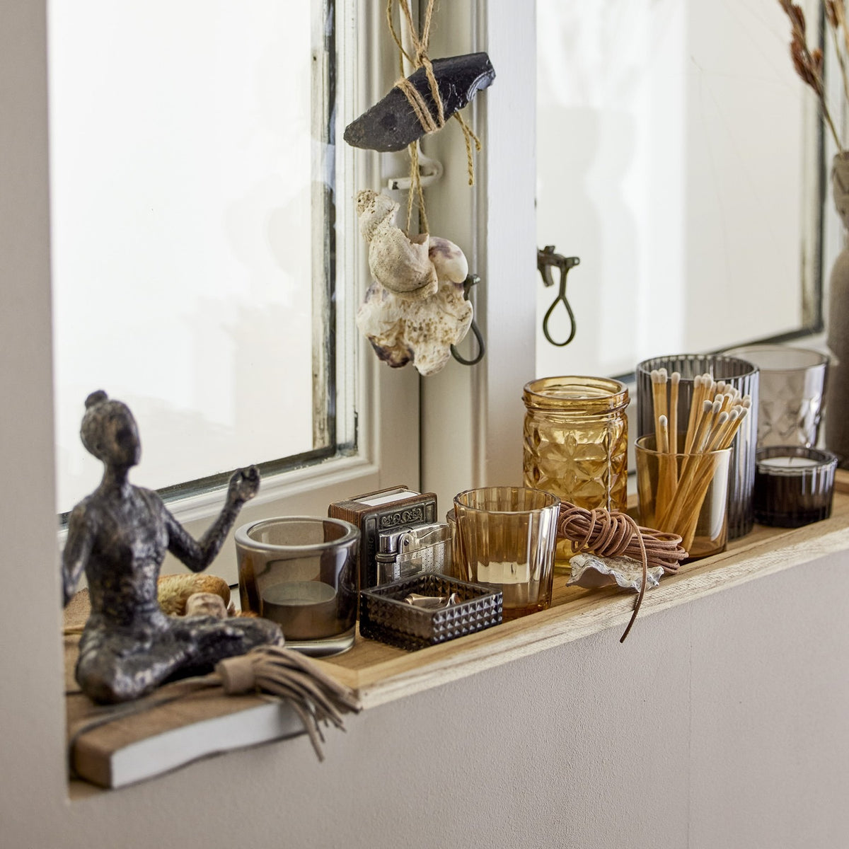Sanga brown glass tealight holders in varied ribbed, faceted and diamond designs, shown on a wooden windowsill among shells, string lights and decor.