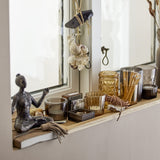 Sanga brown glass tealight holders in varied ribbed, faceted and diamond designs, shown on a wooden windowsill among shells, string lights and decor.