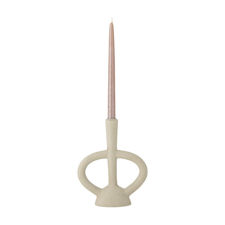 Ramina resin candle holder in beige, with a slender stem, flared foot, and two looped arms, holding a pink taper candle on a plain white background.