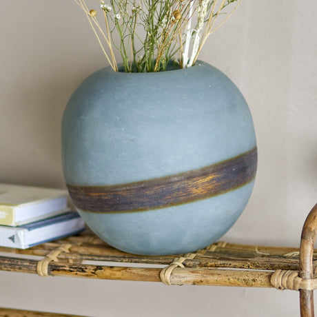 Melike Striped Glass Vase 18.5cm in Blue, a round frosted glass vase with a dark uneven centre band, shown with dried flowers on a woven shelf.