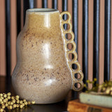 Souri Stoneware Vase 23cm in brown, rounded ceramic body with cinched waist and a side column of open ring loops, shown on a dark surface.