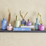 Maien Speckled Stoneware Vases, 14cm set of 7 in blue, green, pink and purple speckled glaze, varied bottle and rounded shapes with dried stems, on a dark shelf with books.