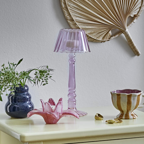 Cisco pink glass tealight holder, 23.5cm lamp-shaped design with fluted shade and twisted stem, styled on a sideboard with decorative accessories.