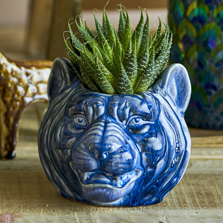 Abner Stoneware Plant Pot in Blue, shaped as a big cat's head with sculpted ears and facial features, holding a spiky green succulent on a tabletop.