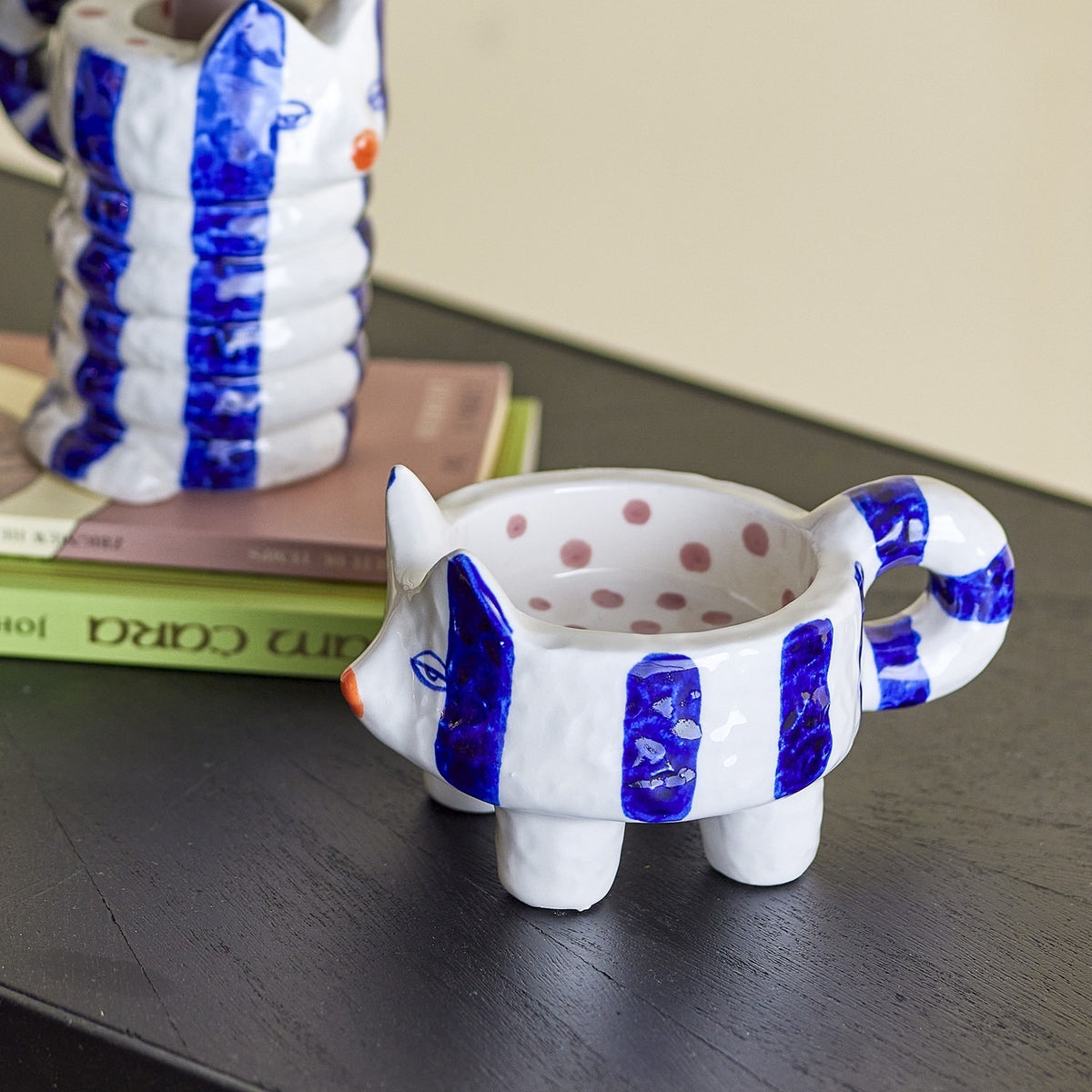 Caty Striped Stoneware Candle Holders Set of 2 in blue, cat-shaped with pointed ears, curled tail handle and polka-dot interior, shown on a dark surface beside a taller matching piece.