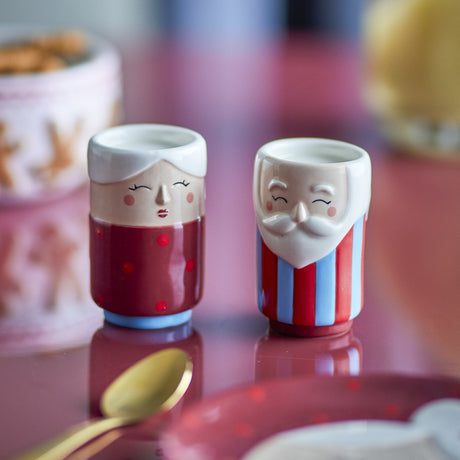 Granny Embossed Christmas Salt & Pepper Shakers set of 2 in red, ceramic figures with embossed faces, one in a polka dot top, the other in red and blue stripes, on a table setting.