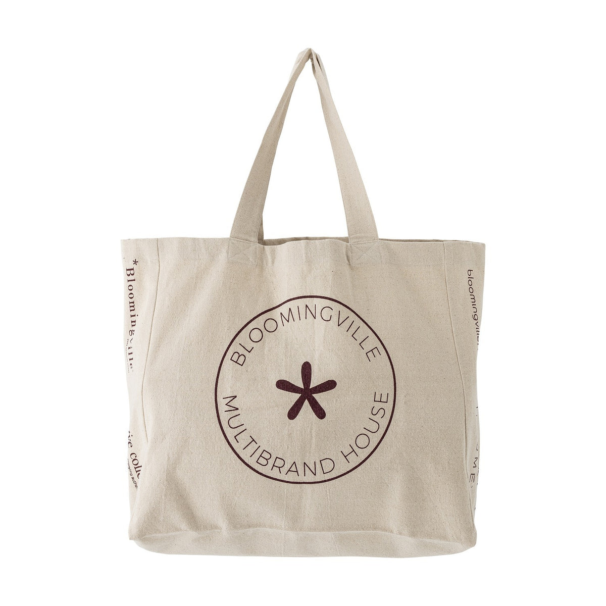 Beige cotton shopping tote with long handles, featuring a circular "Bloomingville Multibrand House" badge and star motif on the front, shown on a white background.